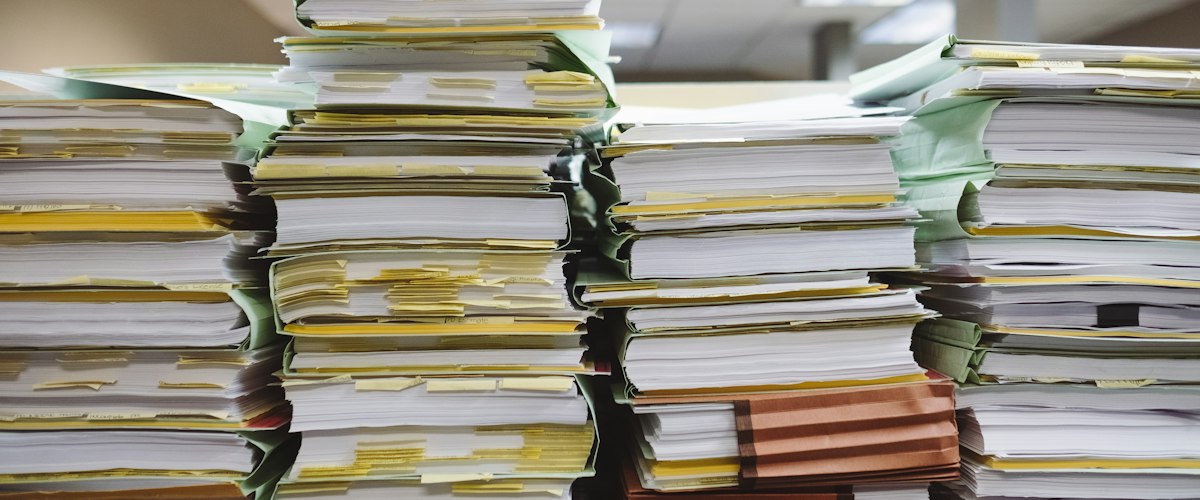 Stacks of paper documents and file folders